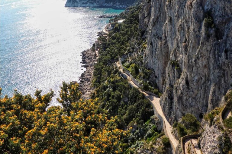 A winding path wraps around the cliffs of Amalfi
