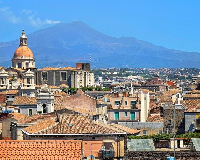 mount etna looms over the city of catania in sicily